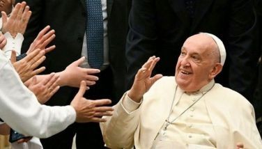 Pope Francis waves during an audience with Hungarian pilgrims in Paul VI hall at the Vatican on April 25, 2024.