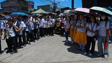 Students use umbrellas to protect themselves from the sun as they line up to wait for their classes outside their school in Manila on April 2, 2024. More than a hundred schools in the Philippine capital shut their classrooms on April 2, as the tropical heat hit &quot;danger&quot; levels, education officials said. 