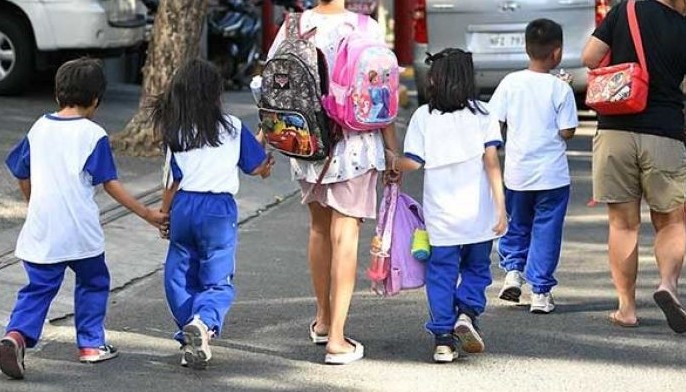 Parents accompany their children from school after their classes in Manila on April 5, 2024. Thousands of schools in the Philippines suspended in-person classes on April 5, the education department said, as parts of the tropical country endured dangerously high temperatures.