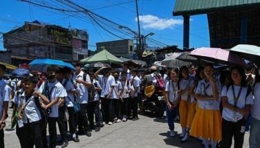 Students use umbrellas to protect themselves from the sun as they line up to wait for their classes outside their school in Manila on April 2, 2024. More than a hundred schools in the Philippine capital shut their classrooms on April 2, as the tropical heat hit &quot;danger&quot; levels, education officials said. a