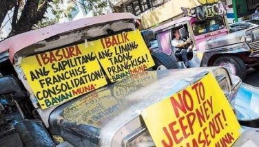 A jeepney plying its route in Manila passes a unit taking part in a transport strike yesterday against the government&acirc;��s Public Utility Vehicle Modernization Program.