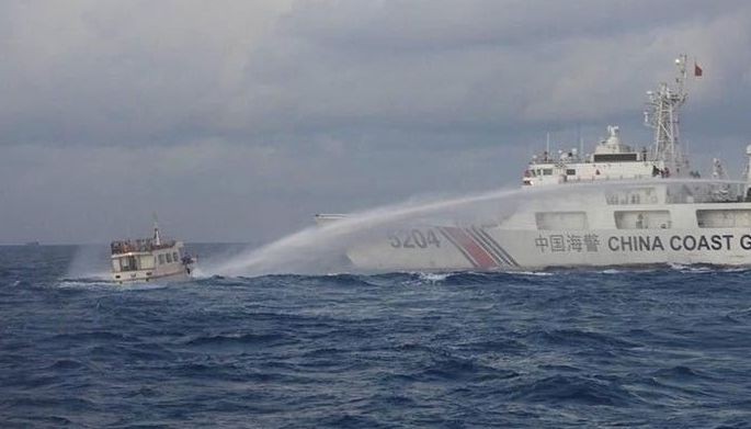 Handout photo from Philippine Coast Guard shows a China Coast Guard vessel firing a water cannon at a Philippine boat on a resupply mission. 