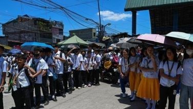Students use umbrellas to protect themselves from the sun as they line up to wait for their classes outside their school in Manila on April 2, 2024. More than a hundred schools in the Philippine capital shut their classrooms on April 2, as the tropical heat hit &quot;danger&quot; levels, education officials said. 