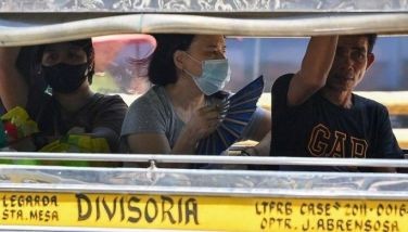 A woman cools off with a folding hand fan inside a passenger jeepney in Manila on April 25, 2024. Extreme heat is scorching parts of South and Southeast Asia, prompting health warnings from authorities as high temperatures are recorded across the region. 
