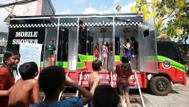 Residents queue at the mobile shower provided by the local government and the Valenzuela City DIsaster Risk Reduction and Management Office to cool off from the scorching heat at Barangay Marulas in Valezuela City on May 1, 2024.