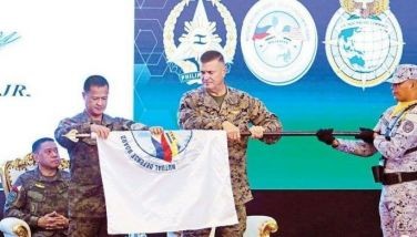 Philippine Balikatan director Army Maj. Gen. Marvin Licudine and US First Marine Expeditionary Force commander Lt. Gen. Michael Cederholm furl the Balikatan flag during the closing ceremony of the joint military exercises, at Camp Aguinaldo yesterday. 