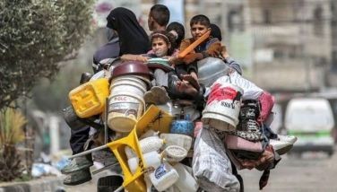 A man, woman, and children ride in the back of a tricycle loaded with belongings and other items as they flee bound for Khan Yunis, in Rafah in the southern Gaza Strip on May 11, 2024 amid the ongoing conflict in the Palestinian territory between Israel and Hamas. 