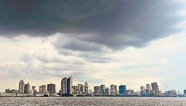 Dark clouds are seen over the Manila skyline yesterday. Isolated rainshowers or thunderstorms are expected over Metro Manila and the rest of the country due to the shearline and easterlies.