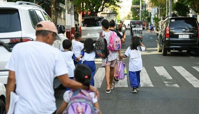 Parents accompany their children from school after their classes in Manila on April 5, 2024. Thousands of schools in the Philippines suspended in-person classes on April 5, the education department said, as parts of the tropical country endured dangerously high temperatures.