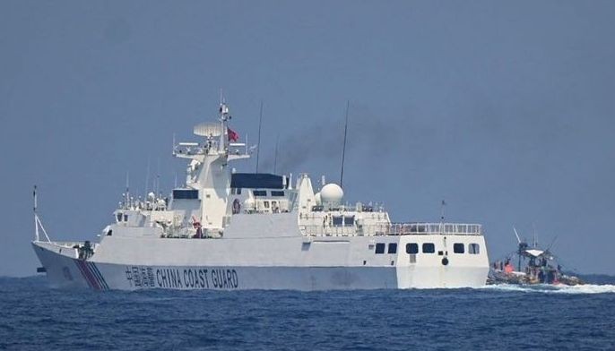 A China Coast Guard ship maneuvers past a Philippine fishing boat during the distribution of fuel and food to fishers by the civilian-led mission Atin Ito (This Is Ours) Coalition, in the disputed South China Sea on May 16, 2024. A Philippine boat convoy bearing supplies for Filipino fishers said they were headed back to port May 16, ditching plans to sail to a Beijing-held reef off the Southeast Asian country after one of their boats was &quot;constantly shadowed&quot; by a Chinese vessel.