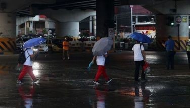 Motorcycle riders and pedestrians find shelter from the rain under the Kamuning Flyover in Quezon City following a brief sudden downpour on May 9, 2024.