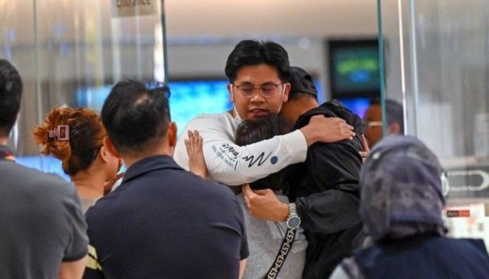 Passengers of Singapore Airlines flight SQ321 from London to Singapore, which made an emergency landing in Bangkok, greet family members upon arrival at Changi Airport in Singapore on May 22, 2024. A 73-year-old British man died and more than 70 people were injured May 21, 2024 in what passengers described as a terrifying scene aboard a Singapore Airlines flight that hit severe turbulence, triggering an emergency landing in Bangkok.