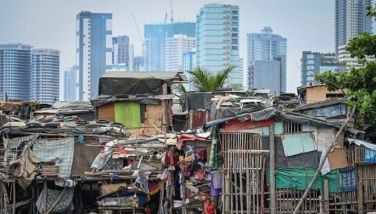 People collect trash under makeshift houses in Manila on May 6, 2024.
