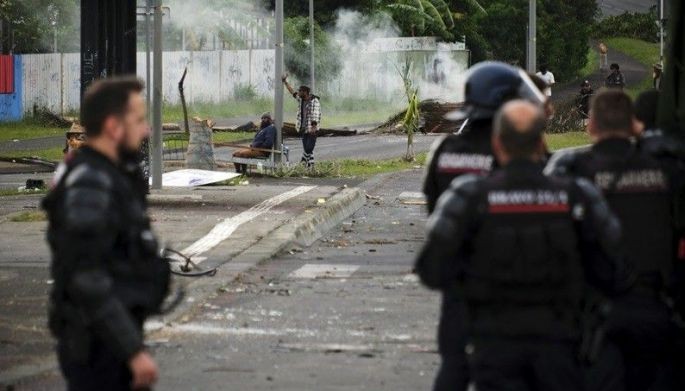 French gendarmes stand guard near independantists at the entrance of the Riviere Salee disctrict, in Noumea, France's Pacific territory of New Caledonia, on May 29, 2024. Riots sparked by a constitutional reform project broke out on May 13. France has lifted a state of emergency across the territory after two weeks of unrest in which seven people died and hundreds were injured 