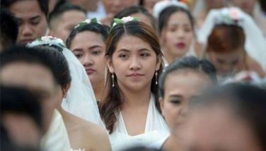 Couples proceed along during a mass wedding in Manila on February 14, 2019, as part of Valentine's Day celebrations. Some 200 couples reportedly took part in the event.