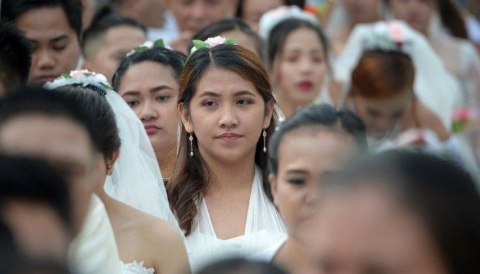 Couples proceed along during a mass wedding in Manila on February 14, 2019, as part of Valentine's Day celebrations. Some 200 couples reportedly took part in the event.