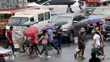 Pedestrians use umbrellas and other items to shield themselves from the sudden downpour in Quezon City on May 25, 2024.