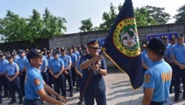Police Regional Office-Central Luzon Director Brig. Gen. Jose Hidalgo Jr., (holding flag) presides over the turnover ceremony at Bamban Municipal Police Station in Tarlac province on Monday (June 3, 2024). A total of 49 officers of the town were relieved pending investigation into the alleged illegal operations of Philippine Offshore Gaming Operators.