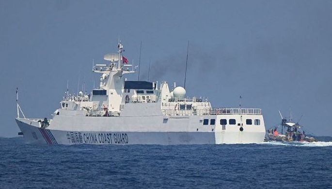A China Coast Guard ship maneuvers past a Philippine fishing boat during the distribution of fuel and food to fishers by the civilian-led mission Atin Ito (This Is Ours) Coalition, in the disputed South China Sea on May 16, 2024. 