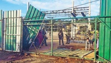 Police tear down the gate of a Kingdom of Jesus Christ compound located at the Glory Mountain property of religious leader Apollo Quiboloy in Tamayong, Calinan, Davao City yesterday&Acirc;&nbsp;during a search for the wanted pastor.