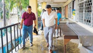 Education Secretary Sonny Angara visits Masambong High School in Quezon City yesterday where heavy flooding damaged classrooms and teaching materials. 