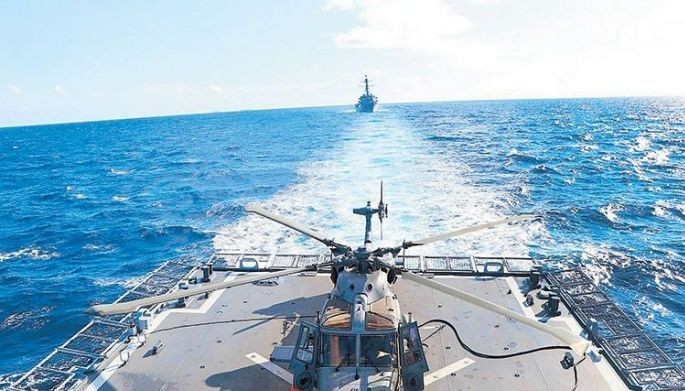 A multi-role AW159 helicopter prepares for takeoff from the BRP Jose Rizal frigate, with the USS Howard destroyer trailing, during anti-submarine drills as part of the Sama-Sama military exercises in the West Philippine Sea on Oct. 14