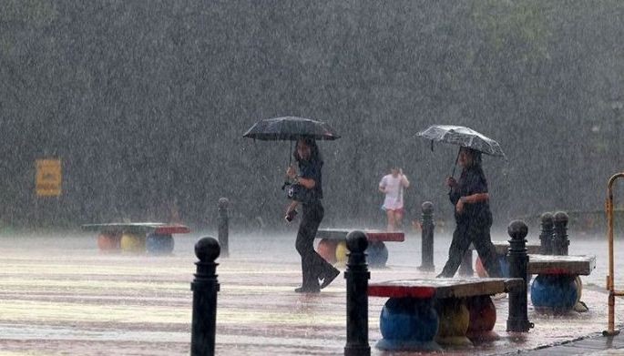 Park-goers walk through the heavy dowmpour inside the Quezon Memorial Circle in Quezon City on Oct. 16, 2024.