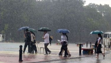 Park-goers walk through the heavy downpour inside the Quezon Memorial Circle in Quezon City on Oct. 16, 2024.