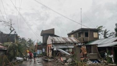 This handout photo released on November 17, 2024 through the courtesy of John Marshal Aquino Facebook page shows residents walking past destroyed houses in Panganiban town, Catanduanes province, after Super Typhoon Man-yi hit the province.