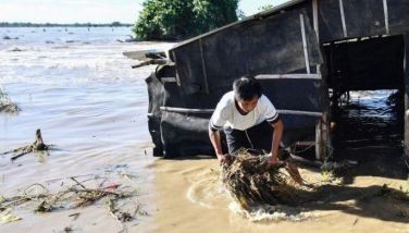 A resident removes grass from his flooded house after a river dike burst at the height of Super Typhoon Man-yi (local name Pepito) at a farming village in Aliaga, Nueva Ecija province on Nov. 19, 2024.