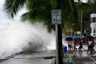 People (R) react as large waves break along a seawall ahead of the expected landfall of Super Typhoon Man-yi, in Legaspi City, Albay province on November 16, 2024. A super typhoon sweeping towards the Philippines on November 16 was intensifying and could have a &quot;potentially catastrophic&quot; impact, the state weather forecaster warned, with millions of people at risk from storm surges.