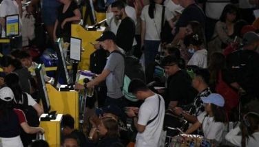 Passengers browse an online check-in kiosk near the departure counters of Cebu Pacific airline at the Terminal 3 of Ninoy Aquino International airport im Manila on July 29, 2024. A major outage wrought havoc on computer systems worldwide, grounding flights in the United States, derailing television broadcasts in the UK and impacting telecommunications in Australia.