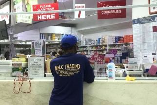 The photo shows a Filipino lining up at a drugstore to purchase medicines over-the-counter.