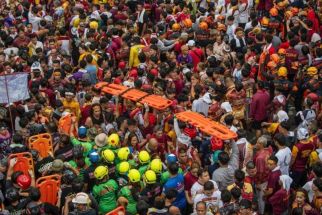 Emergency personnel carrying stretchers walk through Catholic devotees during the annual religious procession of the Black Nazarene in Manila on Thursday, Jan. 9, 2025. Hundreds of thousands of Catholic pilgrims swarmed the streets of Manila in search of a miracle, straining to reach a centuries-old statue of Jesus Christ in an annual display of religious fervour.