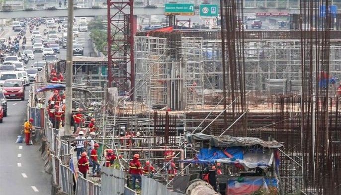 Workers continue the construction of the MRT-7 railway project along Commonwealth Avenue and Elliptical Road on December 23, 2024.