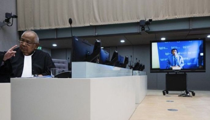 Lawyer Salvador Medialdea (L) sits in the courtroom during the first appearance via video link of his client former Philippine President Rodrigo Duterte (seen on a screen) before the International Criminal Court (ICC) on charge of crimes against humanity over his deadly crackdown on narcotics, in The Hague on March 14, 2025. The 79-year-old, the first ex-Asian head of state to face charges at the ICC, followed by videolink during a short hearing to inform him of the crimes he is alleged to have committed, as well as his rights as a defendant. Duterte stands accused of the crime against humanity of murder over his years-long campaign against drug users and dealers that rights groups said killed thousands.