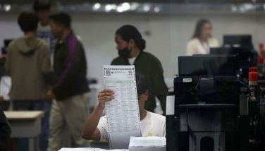 Commission on Elections (Comelec) personnel insert official ballots into machines for verification at the National Printing Office (NPO) in Quezon City on January 15, 2025.