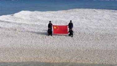 Photo from Chinese state media shows Chinese soldiers holding a flag of the People&acirc;s Republic of China at Sandy Cay.