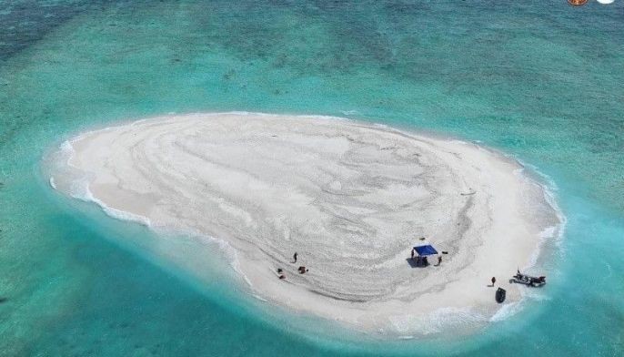 This handout photo taken on March 21, 2024 and received from the Philippine Coast Guard and Bureau of Fisheries and Aquatic Resources (PCG/BFAR) shows an aerial view of Philippine scientists inspecting Sandy Cay reef, near the Philippine-held Thitu Island, in Spratly Islands, in disputed waters of the South China Sea. 