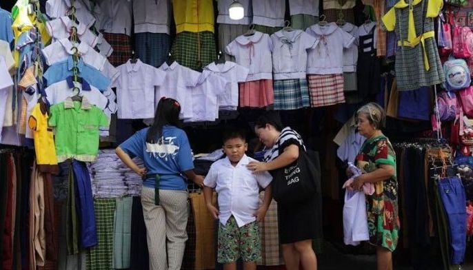 Parents accompany their children for a last-minute shopping of school uniforms and supplies at the Commonwealth Market in Quezon City on June 14, 2025. 