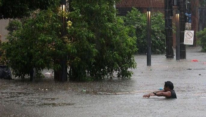 Unattended vehicles are half-submerged in rising flood waters along Mother Ignacia Avenue in Quezon City following torrential rain brought by "habagat" on August 17, 2026.