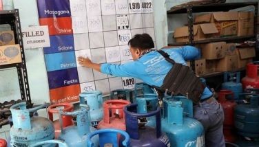 A store helper selling Liquefied Petroleum Gas (LPG) changes the LPG prices on their price board in Paco, Manila on March 25, 2026.