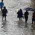Residents wade through floodwaters along Zapote Junction in Las Piñas on August 29, 2026.