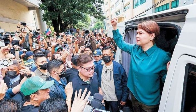 Vice President Sara Duterte, joined by her brother Davao City Rep. Paolo Duterte, arrives at the Quezon City Hall of Justice for her arraignment on grave threat charges, which the court deferred.