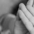 A child raises her hands to cover her face.