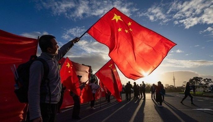 Supporters of China's Premier Li Qiang wave Chinese national flags outside an event held at the Auckland Museum in Auckland on June 14, 2024.